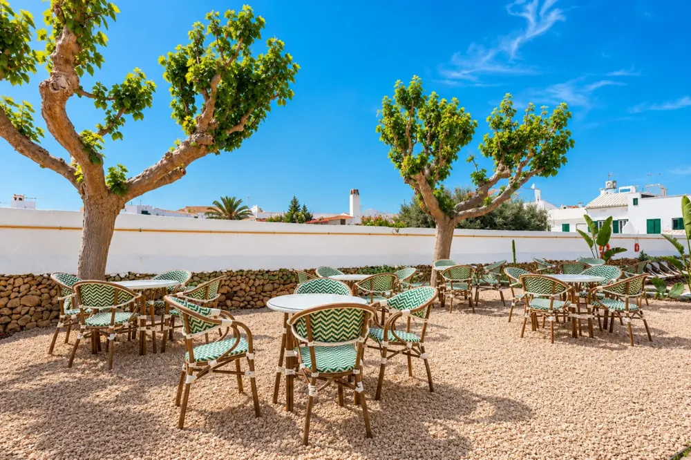 Terraza del Hotel S'Algaret bajo dos plataneros